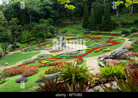 View over the formal garden in the grounds of the Royal Villa at Doi Tung, Northern Thailand. A few people are walking around admiring the plants. Stock Photo