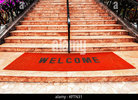 welcome plastic red carpet in front of the marble staircase at the hotel Stock Photo