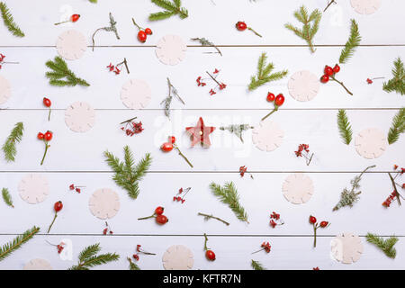 Christmas, New Year or Autumn background, flat lay composition of Christmas natural ornaments and fir branches, berries, rose hips and winter branches covered with moss, empty space for greeting text, congratulations, invitations Stock Photo