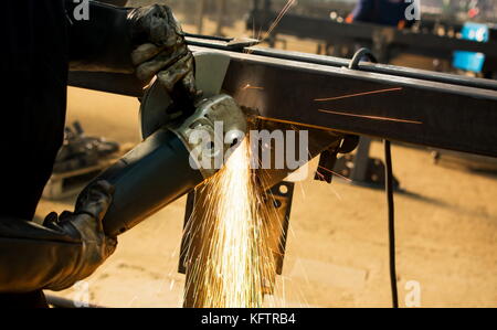 Worker grinding metal with an angle grinder Stock Photo