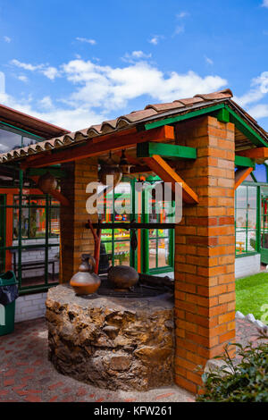 Colombia, South America - A section of The Restaurante El Colonial in Nemocon, In The Cundinamarca Department With An Old Well. Afternoon Sunlight. Stock Photo