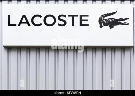 Bremen, Germany - July 2, 2017: Lacoste logo on a wall. Lacoste is a French clothing company, founded in 1933 by tennis player Rene Lacoste Stock Photo