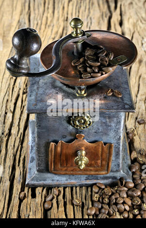 vintage coffee grinder with manufacture roasted Indonesian Arabica coffee beans on rustic wooden background Stock Photo