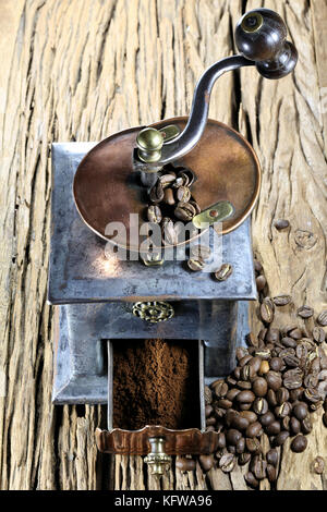 vintage coffee grinder with manufacture roasted Indonesian Arabica coffee beans on rustic wooden background Stock Photo