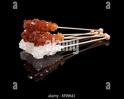 Set lying sticks of brown and white sugar with real reflection on a black glossy background Stock Photo