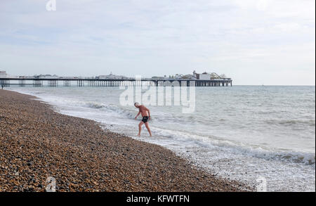 Brighton, UK. 1st November, 2017. A swimmer emerges from the sea off Brighton beach in unusually warm Autumn weather today Credit: Simon Dack/Alamy Live News Stock Photo