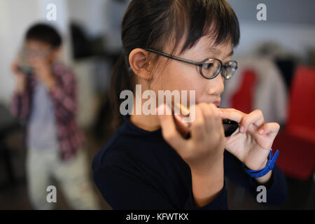 Trossingen, Germany. 1st Nov, 2017. Lenng Tsz Kiu Amanda of the Kings College Old Boys Association from Hong Kong warms up with his harmonica in Trossingen, Germany, 1 November 2017. It is the first day of the World Harmonica Festival 2017. Credit: Felix Kästle/dpa/Alamy Live News Stock Photo