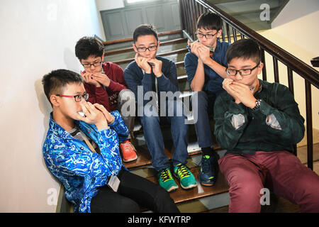 Trossingen, Germany. 1st Nov, 2017. A group of music students of the Kings College Old Boys Association from Hong Kong warm up with their harmonicas in Trossingen, Germany, 1 November 2017. It is the first day of the World Harmonica Festival 2017. Credit: Felix Kästle/dpa/Alamy Live News Stock Photo