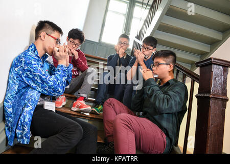 Trossingen, Germany. 1st Nov, 2017. A group of music students of the Kings College Old Boys Association from Hong Kong warm up with their harmonicas in Trossingen, Germany, 1 November 2017. It is the first day of the World Harmonica Festival 2017. Credit: Felix Kästle/dpa/Alamy Live News Stock Photo