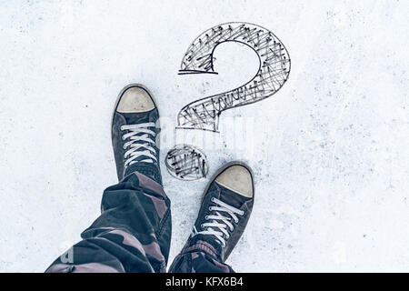 Question mark on the road and sneakers, wondering and asking questions Stock Photo