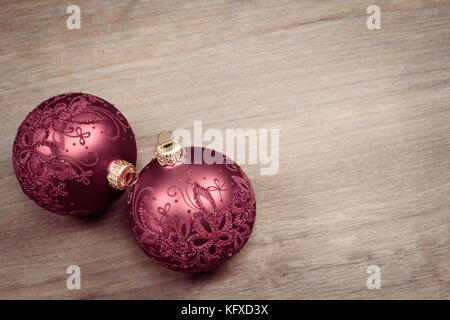 Two Christmas balls isolated on wood background.. Decorated glass baubles. Stock Photo