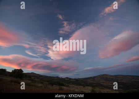 Pink clouds forming over the Greek sky, during sunset hour. Stock Photo