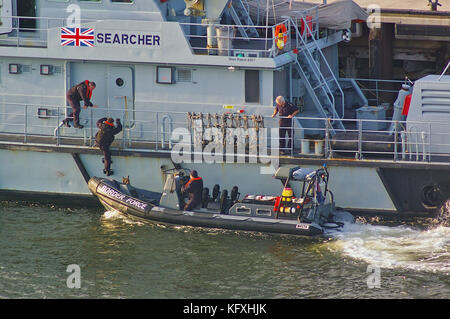 Newcastle, United Kingdom - October 5th, 2014 - UK border force officers boarding a RIB patrol boat alongside the border force cutter HMC Searcher Stock Photo