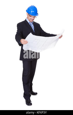 Happy Male Architect Looking At Blueprint On White Background Stock Photo