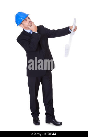 Happy Male Architect Looking At Blueprint On White Background Stock Photo