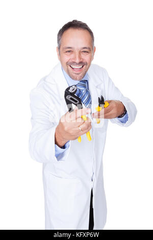 Smiling Male Doctor Holding Pliers On White Background Stock Photo