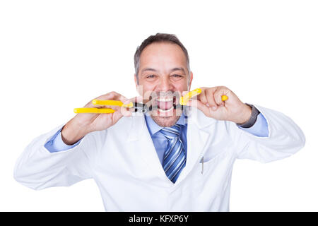 Smiling Male Doctor Holding Pliers On White Background Stock Photo