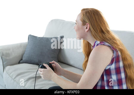 Young woman playing video game against white background Stock Photo