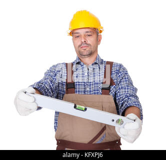 Portrait Of Technician Looking At Level Isolated On White Background Stock Photo
