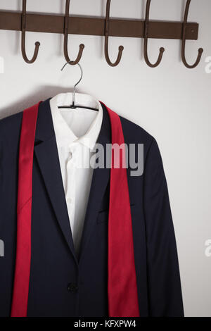Close-up of various shirts hanging on hook against white wall Stock Photo -  Alamy