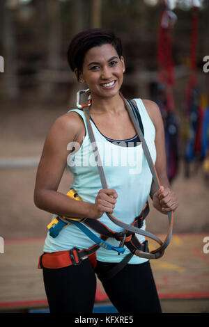 Portrait of smiling woman holding harness in park Stock Photo