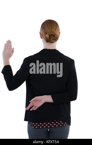 Rear view of businesswoman taking oath with fingers crossed