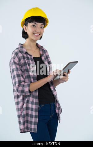 Portrait of smiling female architect using digital tablet against white background Stock Photo