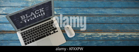 Laptop and mouse on wooden table against black friday Stock Photo