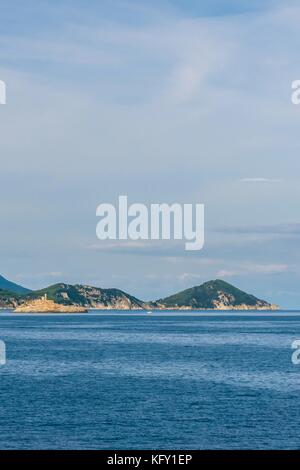 Vertical photo of a coastline of island in Mediterranean Sea. The coast is with several rocks of mountains in Tuscany Italy. The rocks are on Elba isl Stock Photo