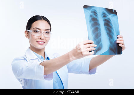 Pleasant young woman holding X-ray examination results Stock Photo