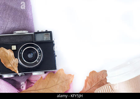 Retro camera and copy space with maple leaves in autumn border design - concept of remembrance and nostalgia in fall season. vintage rustic style.