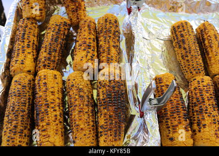 Grilled sweet corn for sale on stall of street food vendor.