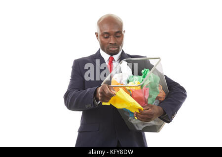 Portrait of African businessman searching document among crumpled papers in paper basket Stock Photo