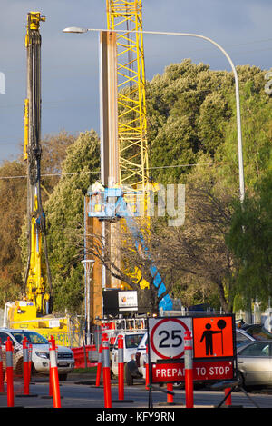 A crane lifts a heavy payload in preparation for the extension of the O-Bahn road through Rymill Park in Adelaide, South Australia. Stock Photo