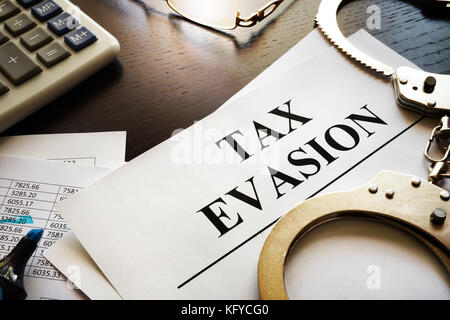 Papers about tax evasion on a desk. Tax avoidance concept. Stock Photo