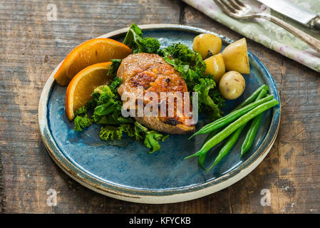 Roast duck fillets with orange marmalade and chilli glaze with boiled potatoes and green vegetables Stock Photo