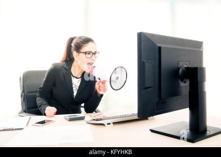 Businesswoman yelling through a megaphone Stock Photo