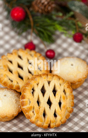 Frsh lattice top mince pies on a country table with some festive seasonal christmas decorations Stock Photo