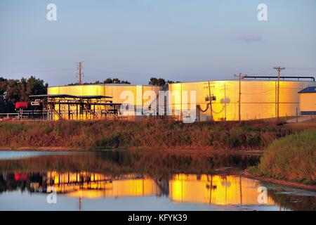 Late afternoon light just prior to sunset shining on and reflecting off fuel storage tanks. Bartlett, Illinois, USA. Stock Photo