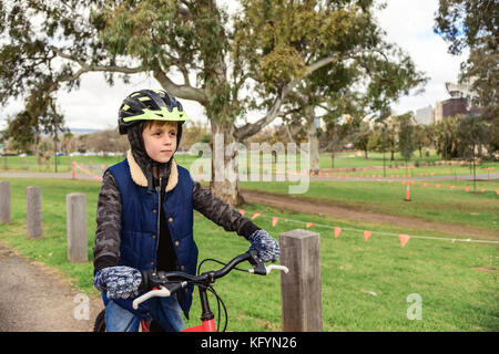 Boy riding bicycle in Adelaide CBD during winter season, South Australia Stock Photo