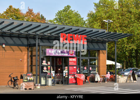 Entrance and sidewalk cafe of a REWE supermarket Stock Photo