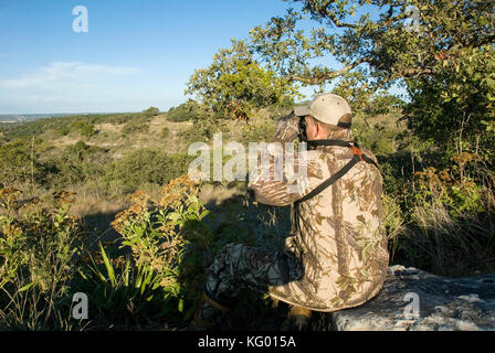 A LONE HUNTER LOOKS FOR WHITETAIL DEER IN THE TEXAS HILL COUNTRY Stock Photo