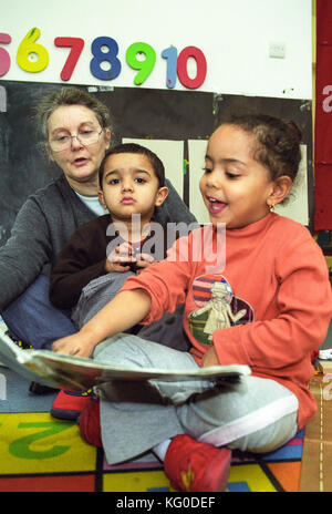 Teacher reading to children at a nursery school Stock Photo