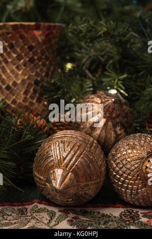 Christmas display with greenery, gold wooden ball ornaments and a red candle holder Stock Photo