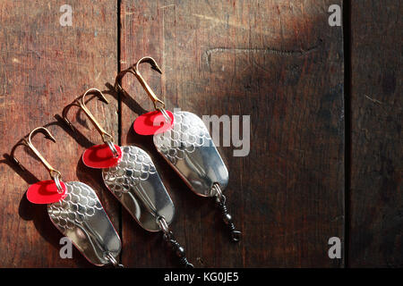 Three spinners lying in a row on wooden surface with copy space Stock Photo