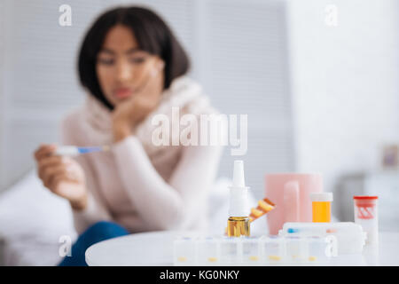 Lots of pills being placed on a white table Stock Photo