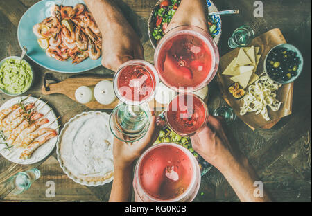 Flat-lay of friends hands eating and drinking together, horizontal composition Stock Photo