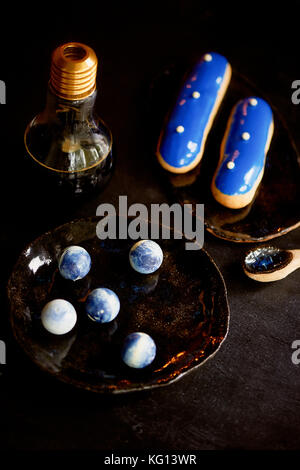 Blue eclairs and candy in blue colors. On a dark background. Pastry arts Stock Photo