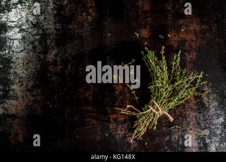 Bunch of fresh organic thyme on an old metallic rusty black background, copy space top view Stock Photo