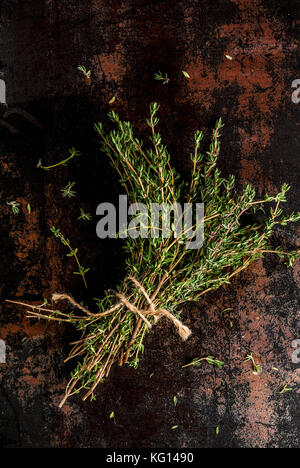 Bunch of fresh organic thyme on an old metallic rusty black background, copy space top view Stock Photo
